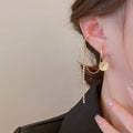 Asymmetric portrait round plaque studded tassel earrings
